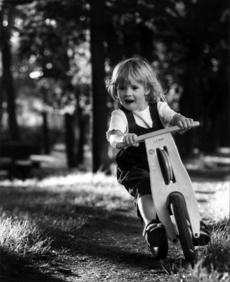 young girl on wooden balance bike
