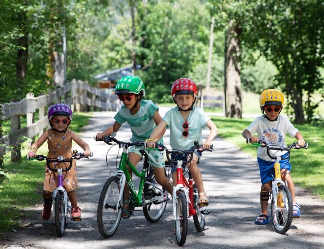 kids riding woom bikes up a road